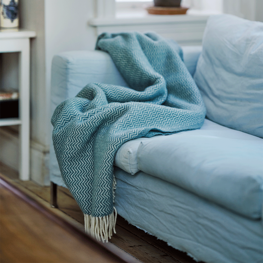 Sorbet Silky Blue throw from Klippan on a blue sofa