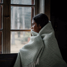Girl by a window wrapped in Preppy green throw from Klippan Homestore