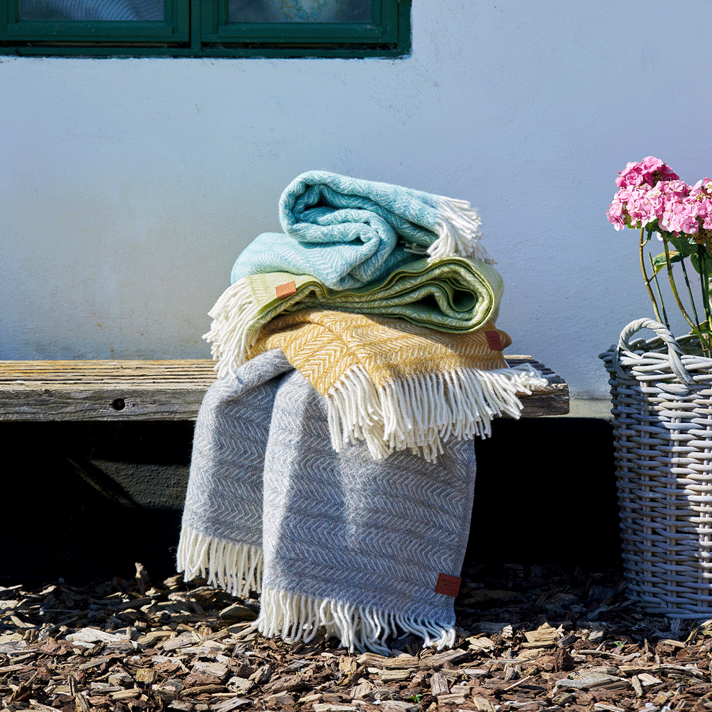 A selection of Klippan Point wool throws on a bench